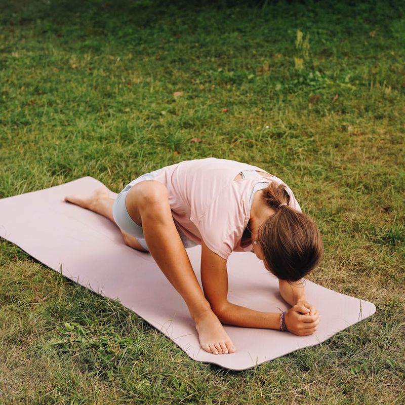 Person stretching on a yoga mat, viewed from above, with lime green elements.